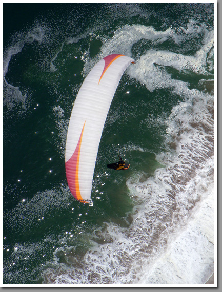 Leo Andrade on his Niviuk Icepeak paraglider during the final glide toward Playa Brava after a successful flight over inland mountain ranges, Iquique, Atacama Desert, Chile