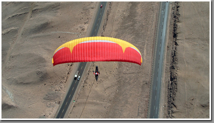 Jarek Wieczorek racing cars in his paraglider, Iquique, The Atacama Desert, Chile